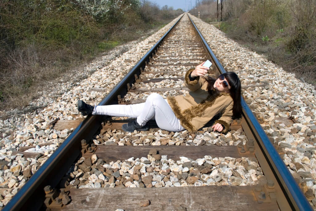 Mujer tomándose una selfie en las líneas del tren