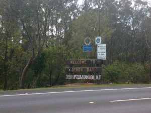 Cartel con la frase "Bienvenido: anímate, reduce la velocidad y relájate" en la entrada a Byron Bay