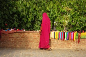 Mujer vestida con una túnica rosada vendiendo pañuelos