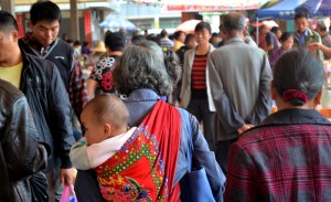 China con bebé en su espalda en el mercado de Fuli
