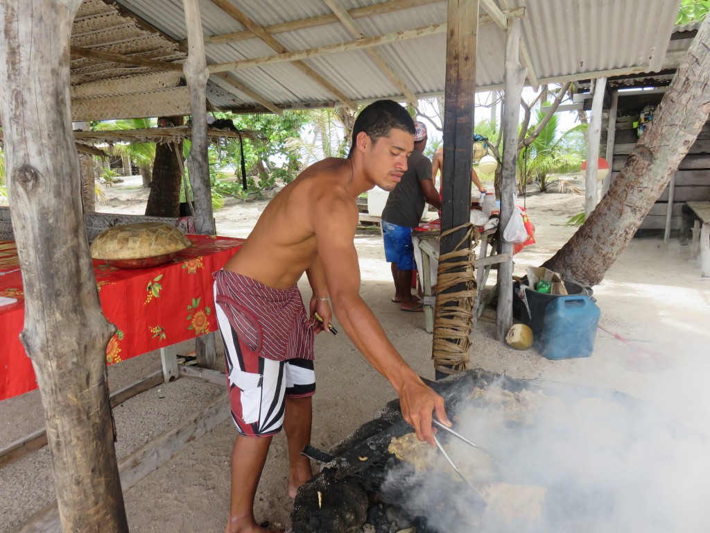 Hombre preparando el asado en el motu