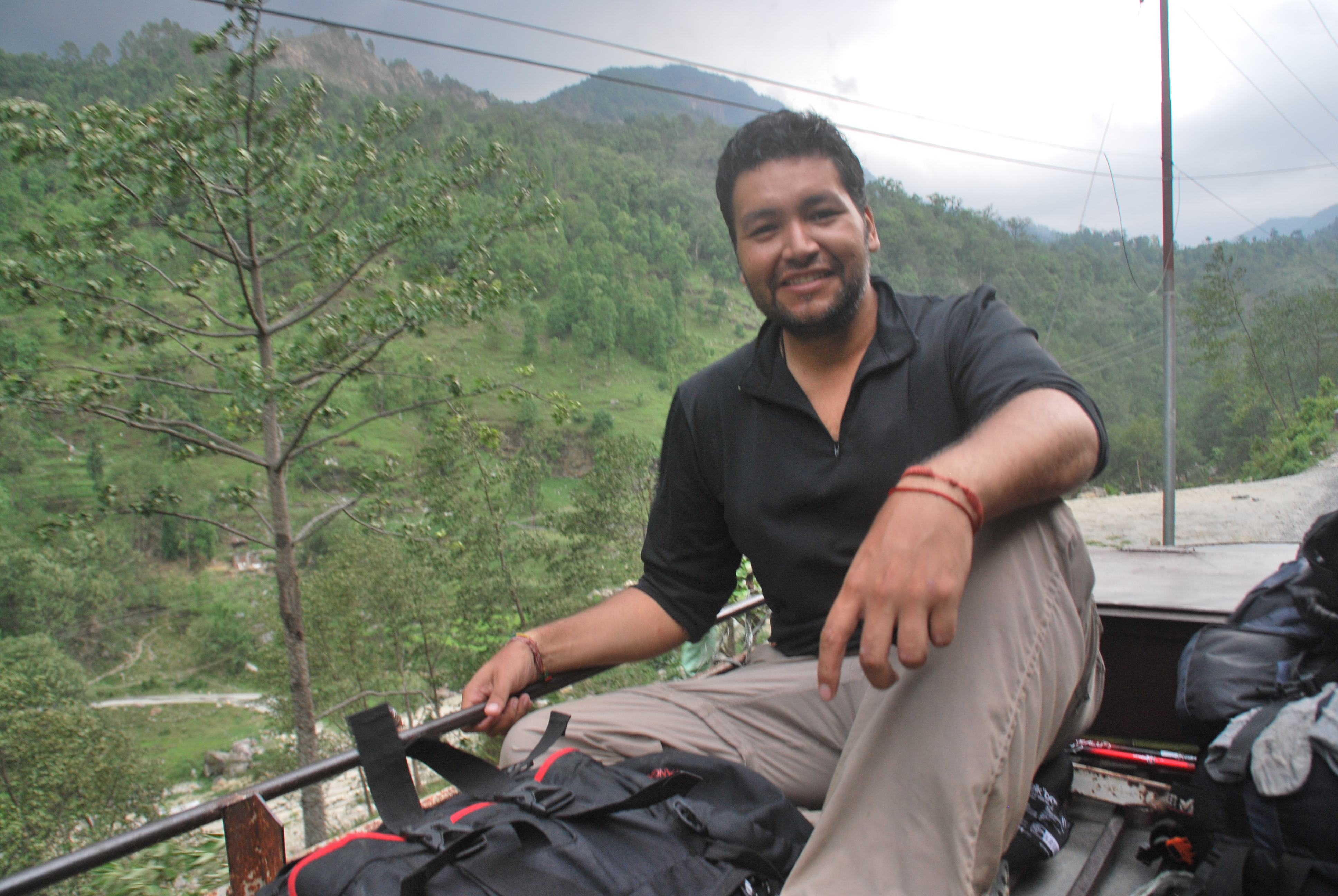 Hugo viajando en el techo de un bus en Nepal