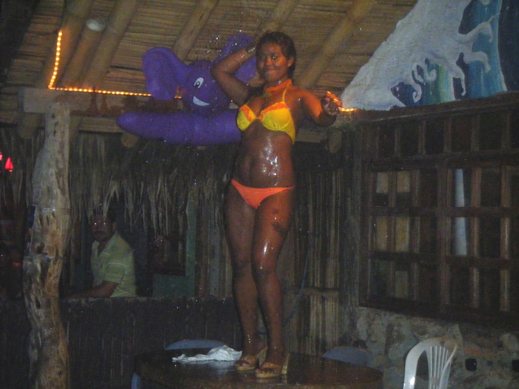 Mujer en bikini sobre la mesa de un bar