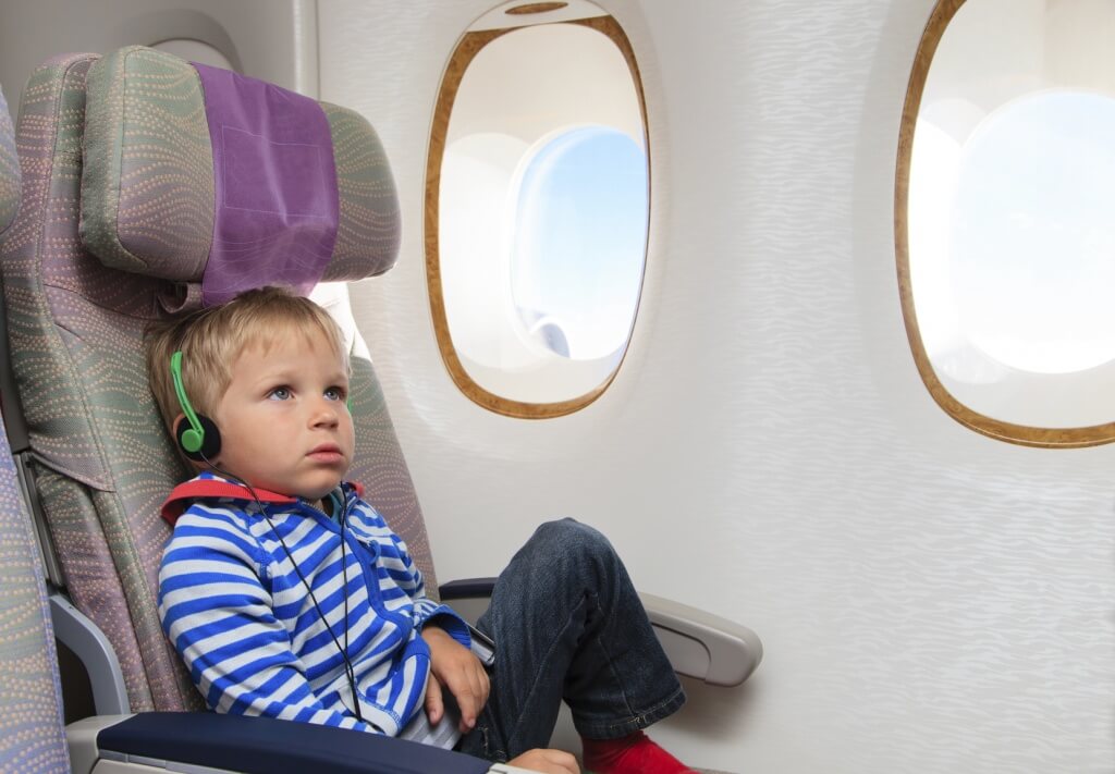 Niño con audífonos en un avión