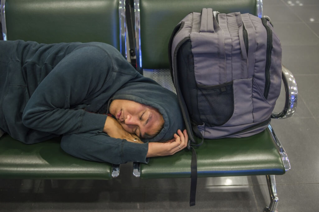 Hombre durmiendo en un aeropuerto