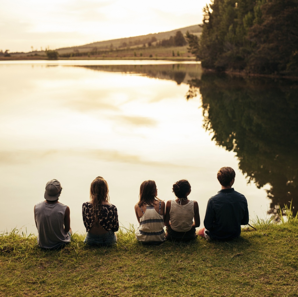 Amigos sentados frente al lago