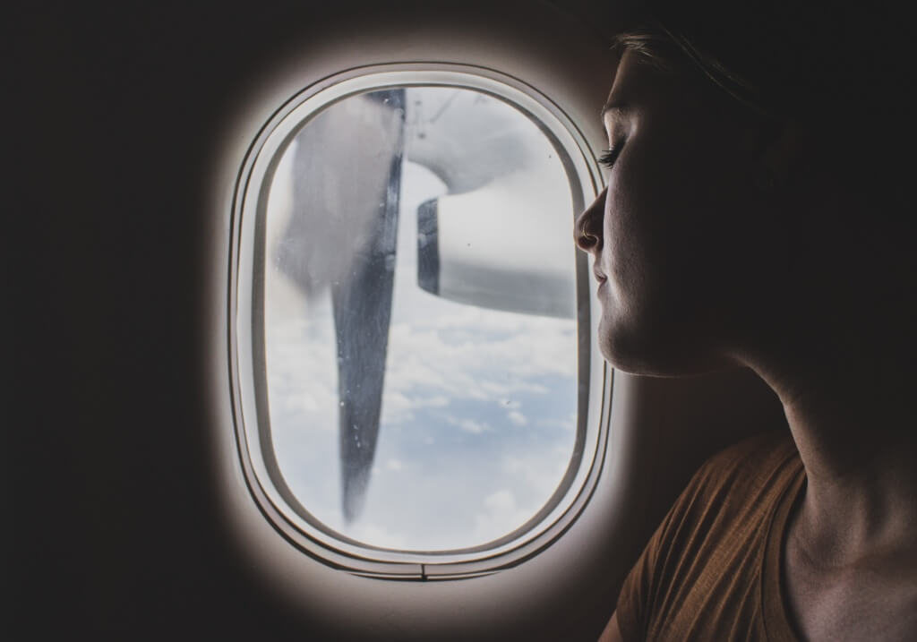 Mujer mirando por la ventana de un avión